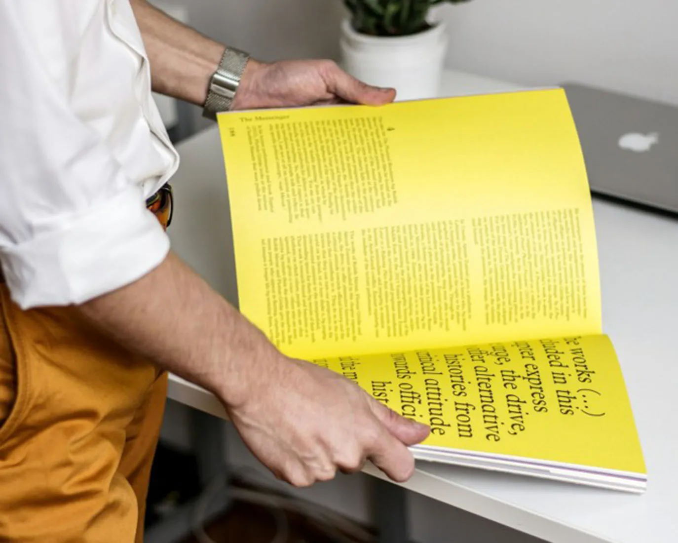 Ein Mann blättert in einem WAS TUN Magazin